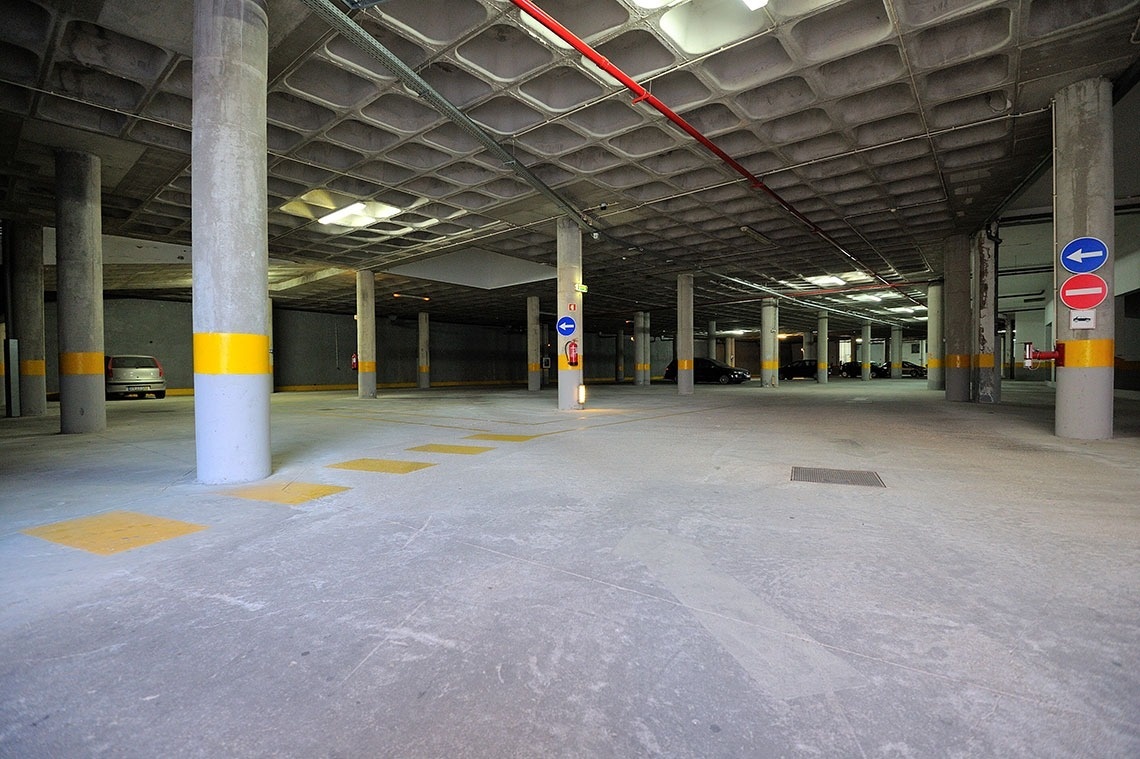 un aparcamiento subterráneo con columnas y un coche estacionado