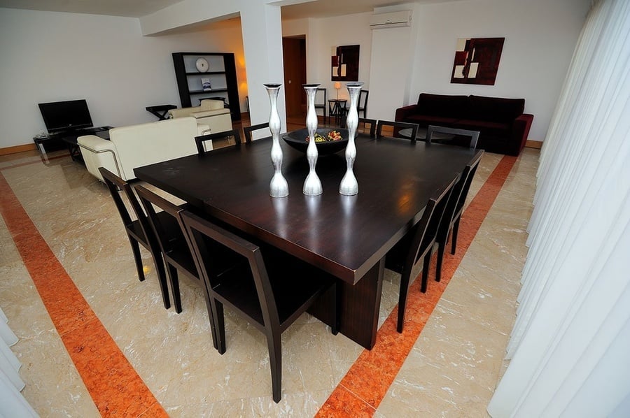 un comedor con una mesa y sillas y un jarrón de frutas