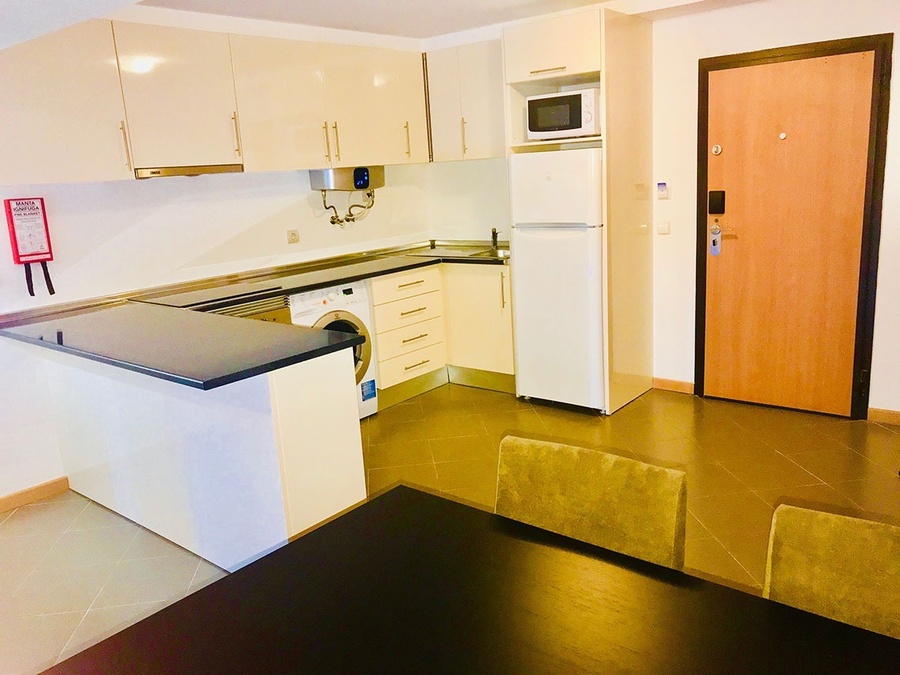 una cocina con una mesa y sillas y un extintor de incendios en la pared