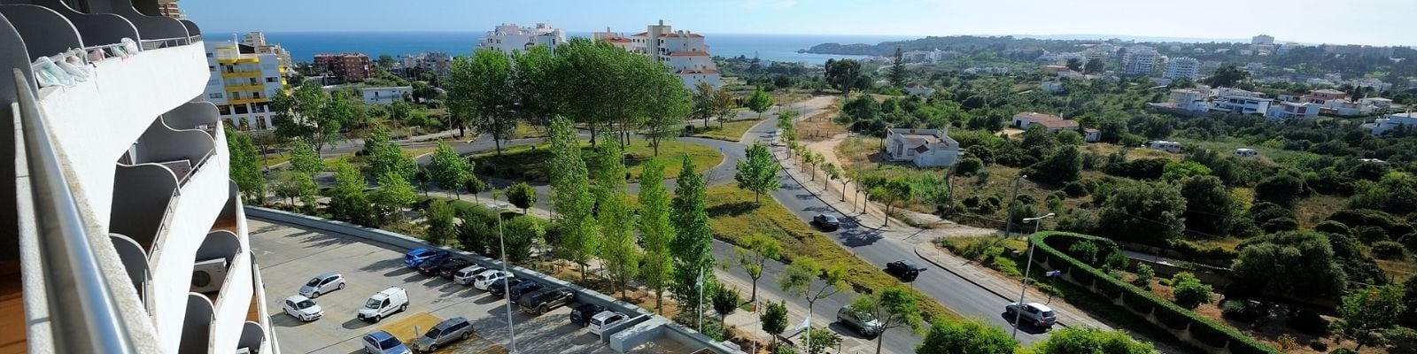 uma vista aérea de uma cidade com muitos carros e árvores