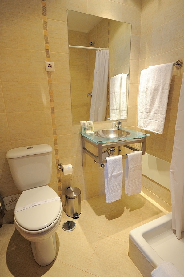 un baño con inodoro , lavabo y espejo