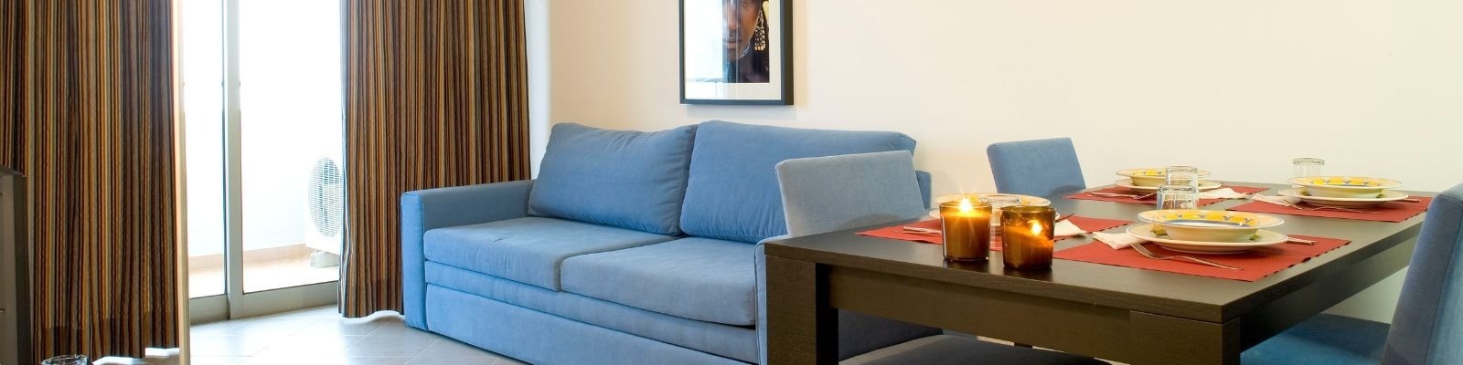 un salon avec un canapé bleu et une table à manger