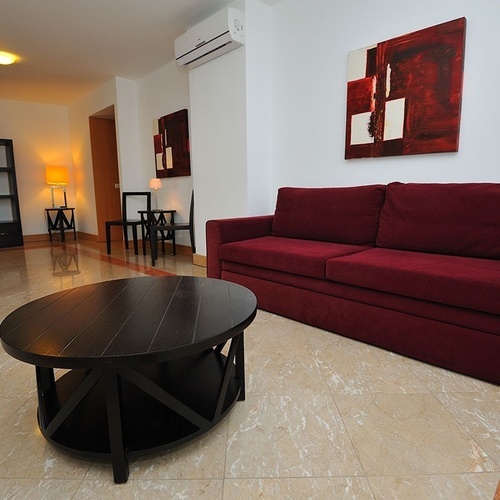 a living room with a red couch and a black coffee table