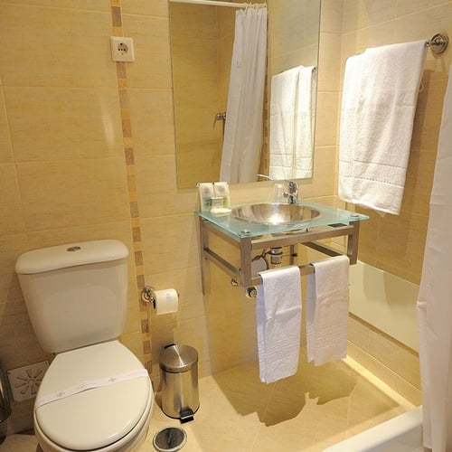 a bathroom with a toilet a sink and a mirror