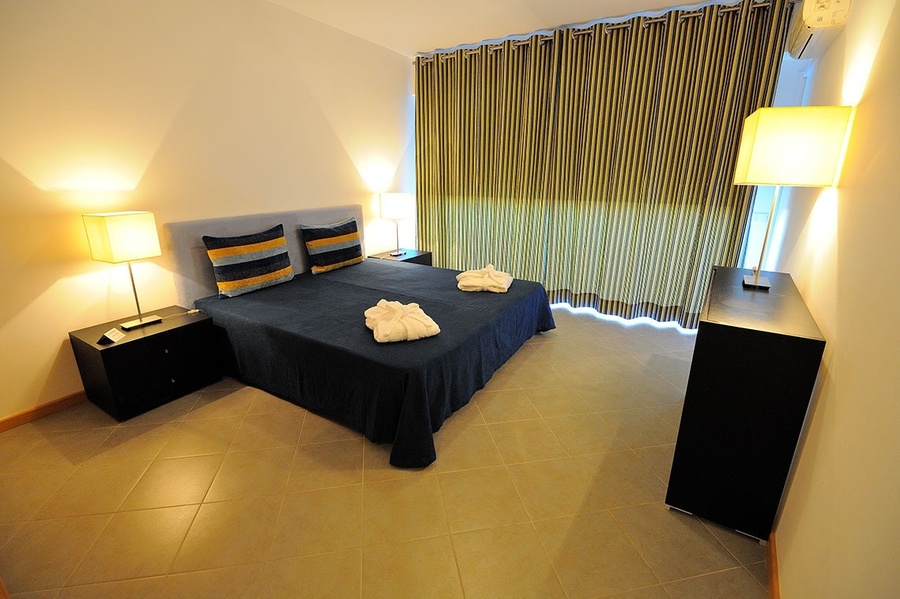 un dormitorio con una cama y dos mesitas de noche