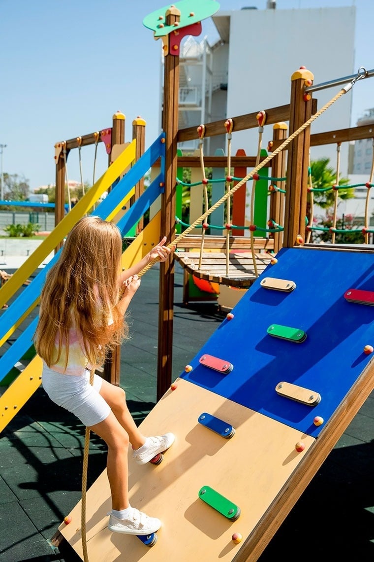 un parque infantil colorido está frente a un edificio de apartamentos