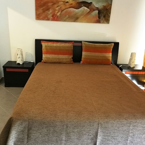 a bedroom with a large painting on the wall above the bed