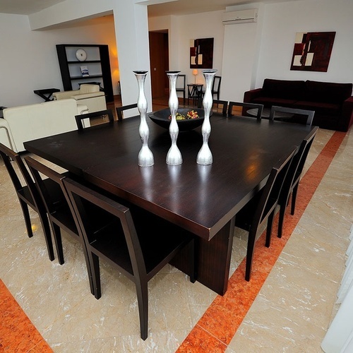 a dining room table with a bowl of fruit on it