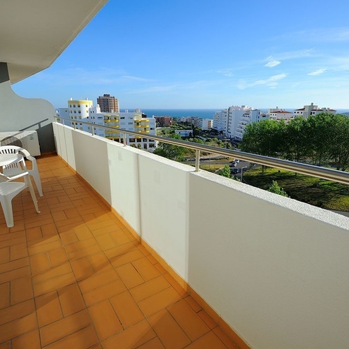 a balcony with a view of a city and the ocean