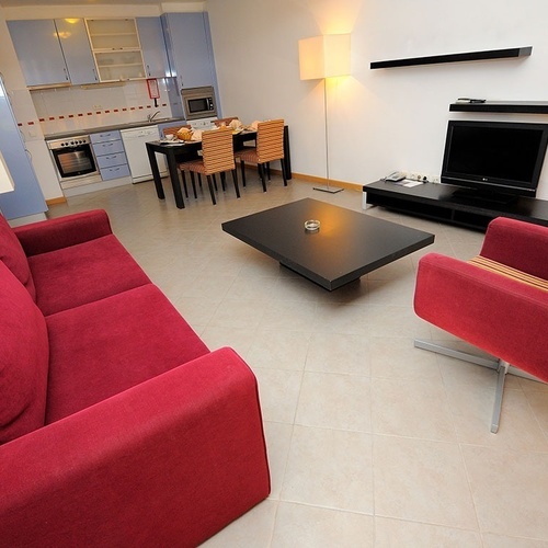 a living room with a red couch and a black table
