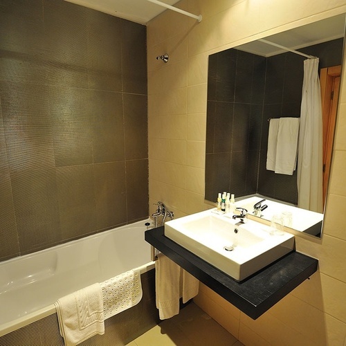 a bathroom with a sink a bathtub and a mirror
