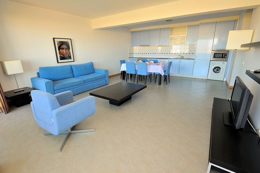 una sala de estar con un sofá azul y una mesa de comedor