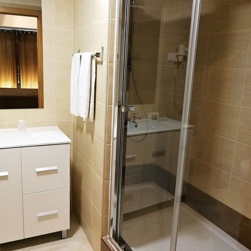 a bathroom with a walk in shower and a sink