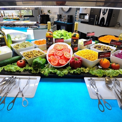 a buffet table with a variety of salads and condiments