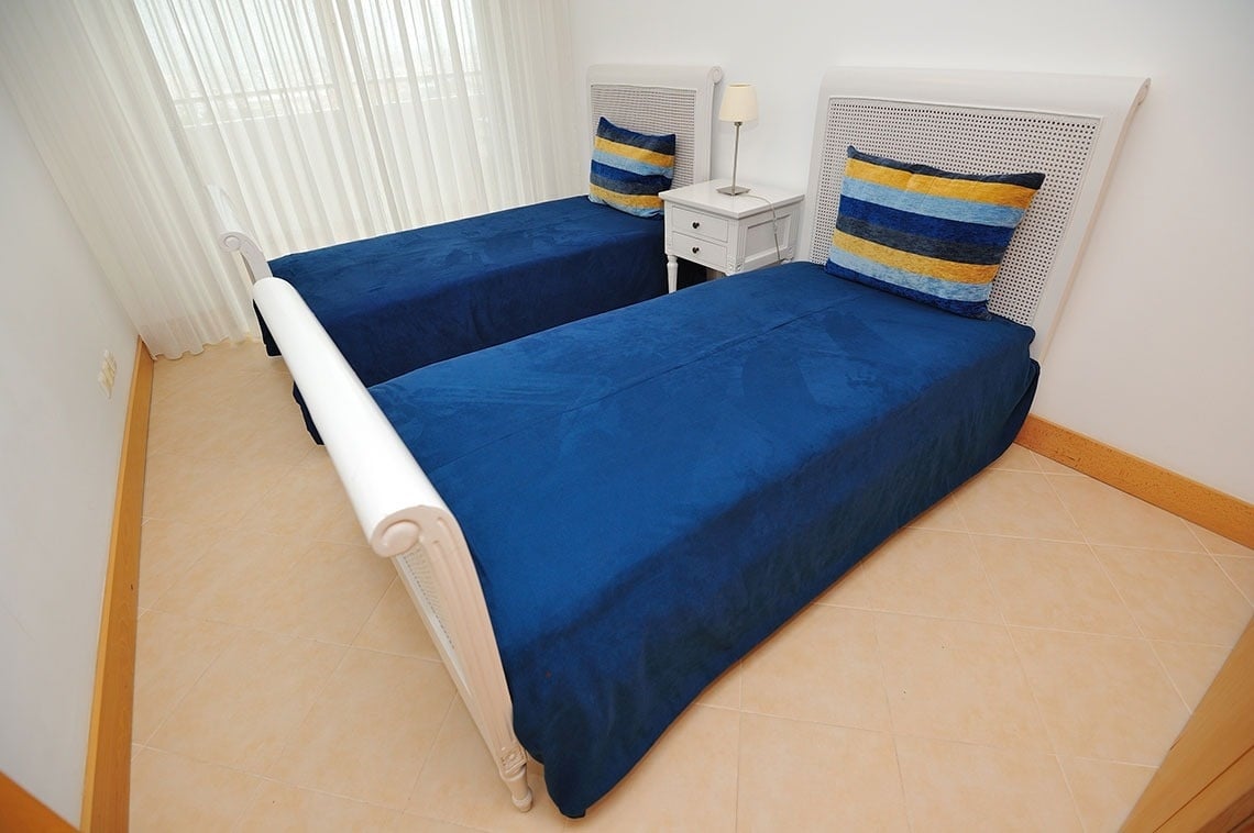 une chambre avec deux lits et une table de chevet