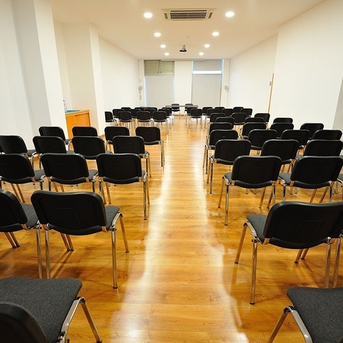 una sala de conferencias llena de sillas negras
