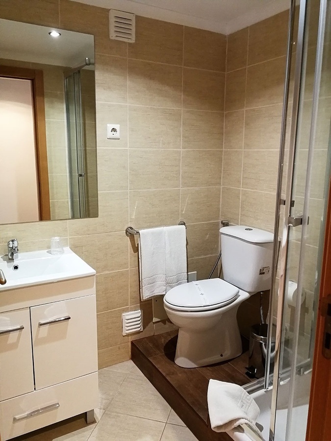 un baño con inodoro , lavabo y espejo