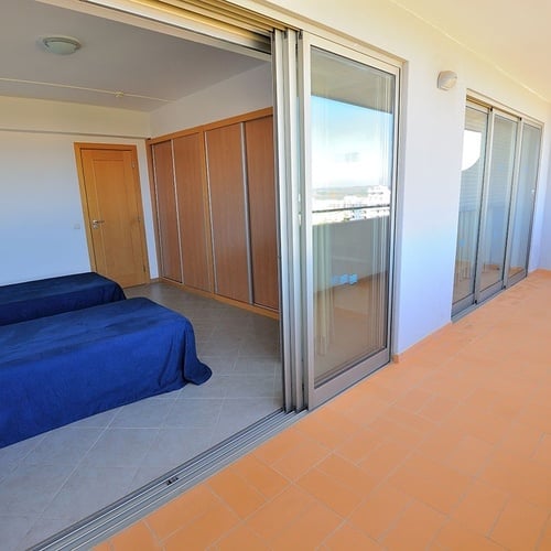 a bedroom with two beds and sliding glass doors