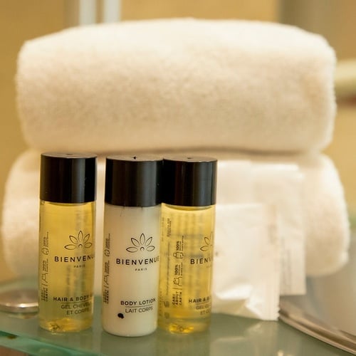 three bottles of bienvenue are on a glass shelf next to a towel