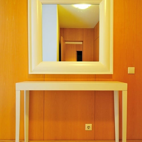 a white table with a large mirror above it