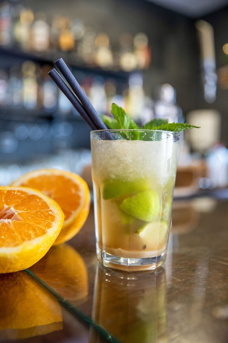 un verre de boisson avec des pailles et des tranches d' orange sur une table .