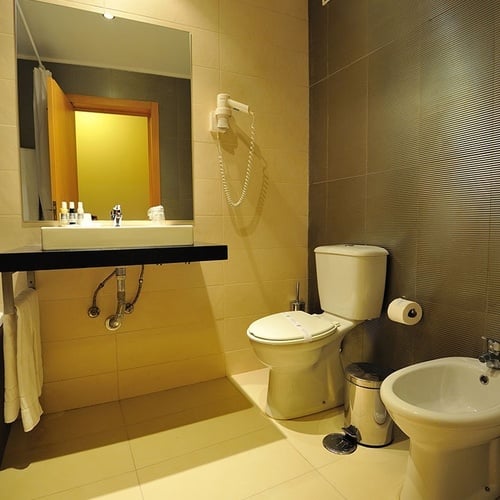 a bathroom with a toilet a sink and a bidet