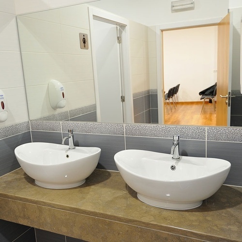 a bathroom with two sinks and two soap dispensers