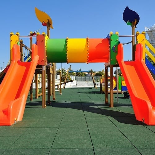 a colorful playground with slides and a tunnel