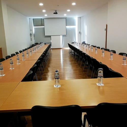 a conference room with tables and chairs and a projector screen