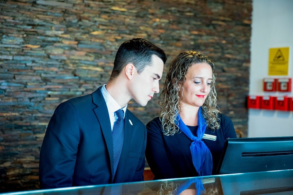 um homem e uma mulher estão olhando para um tablet