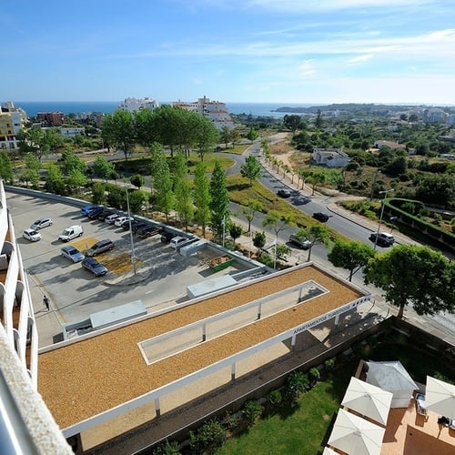 uma vista aérea de um parque de estacionamento ao lado de uma estrada