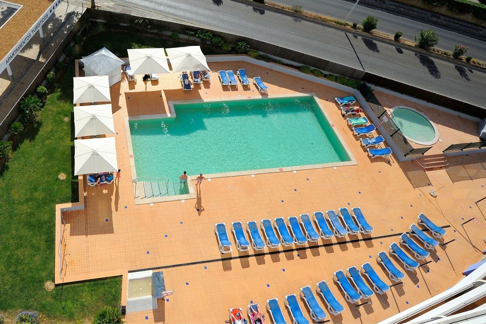 une vue aérienne d' une piscine avec des chaises longues et des parasols