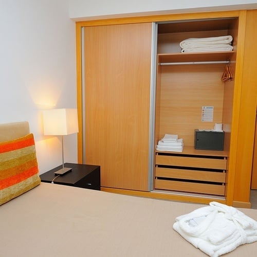 a bedroom with a bed a nightstand and a closet