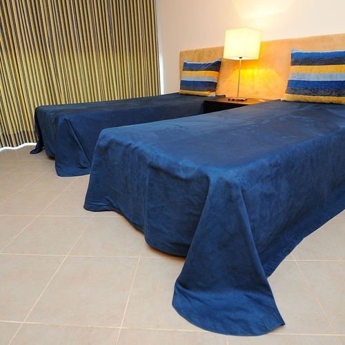 a bedroom with two beds and striped curtains
