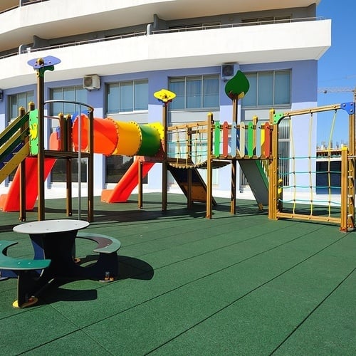 um playground colorido em frente a um prédio