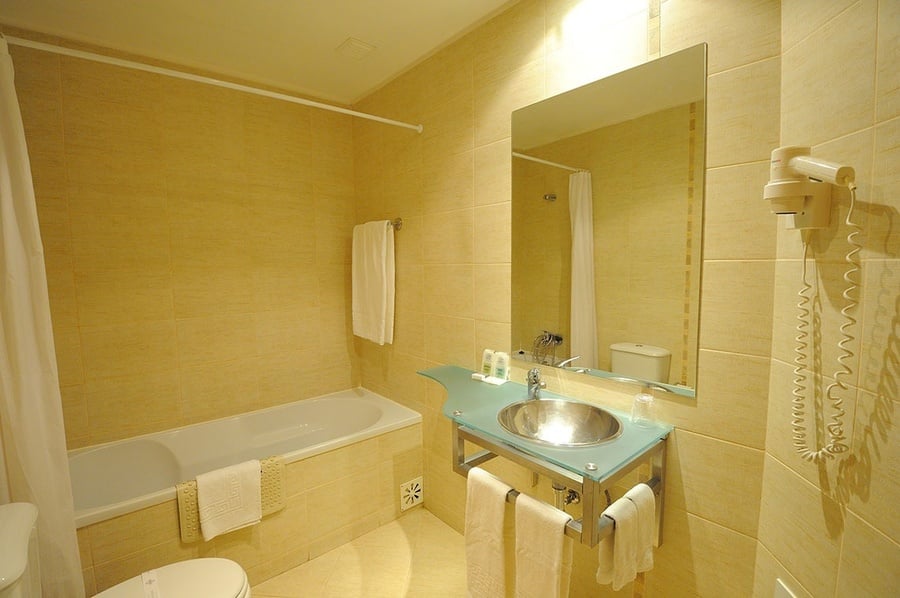 un baño con bañera , lavabo y espejo