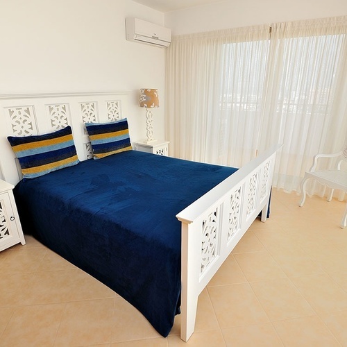 a bedroom with a blue bed and two lamps