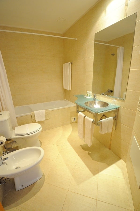 un baño con bañera , inodoro , lavabo y espejo