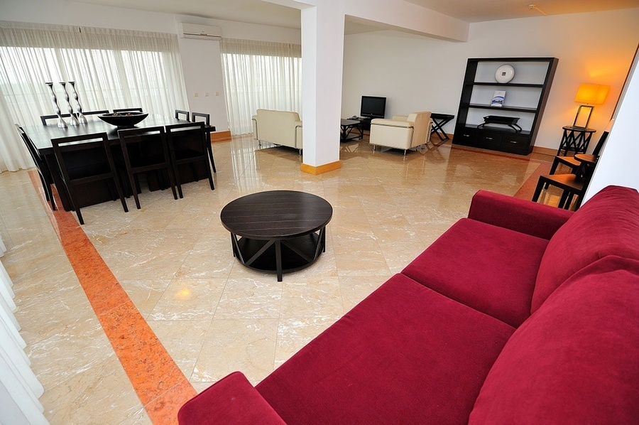 una sala de estar con un sofá rojo y una mesa