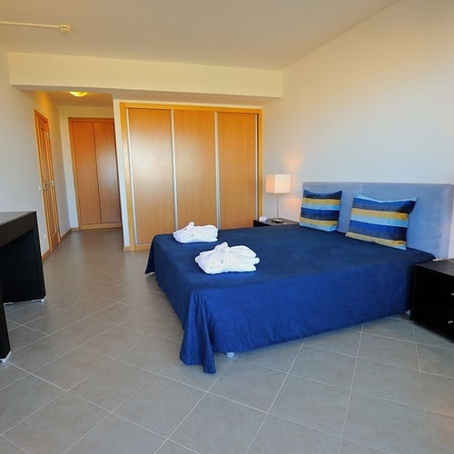 a bedroom with a blue bed and two nightstands