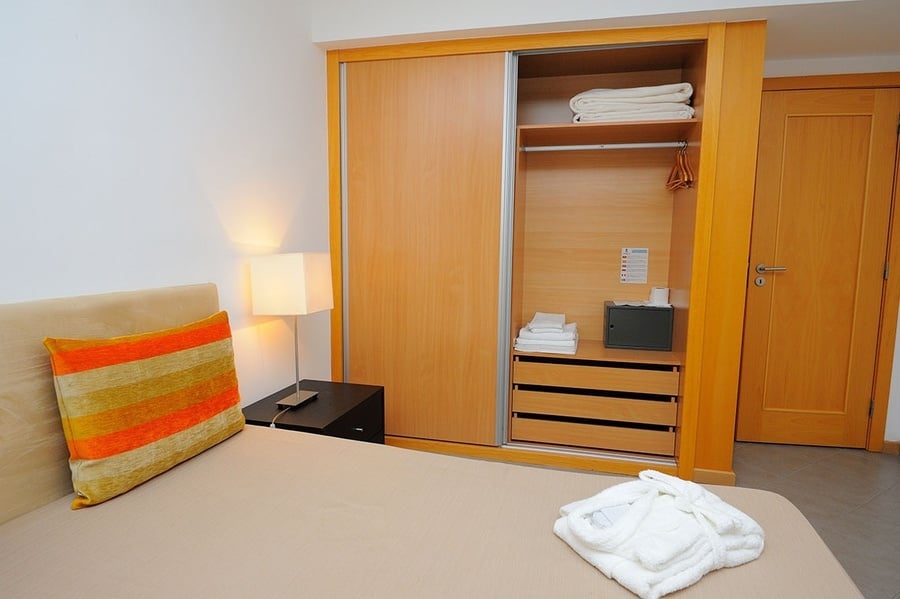 un dormitorio con una cama y un armario de madera