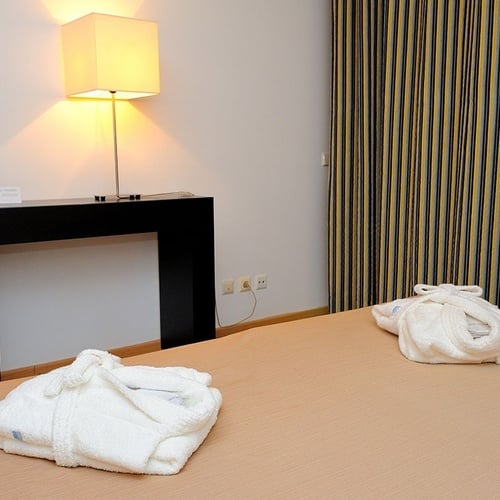 a hotel room with striped curtains and a lamp