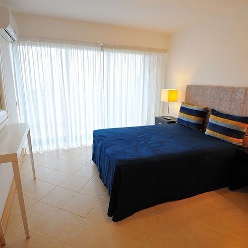 a bedroom with a blue bed and two lamps