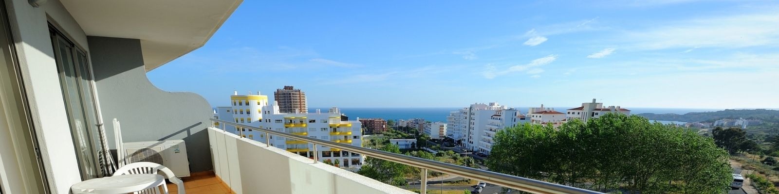 a balcony with a view of a city and the ocean