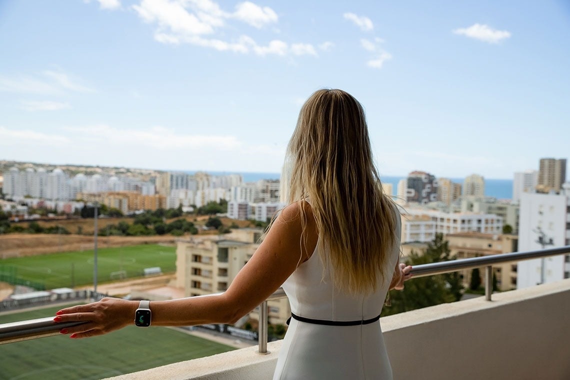 une femme debout sur un balcon regardant la ville