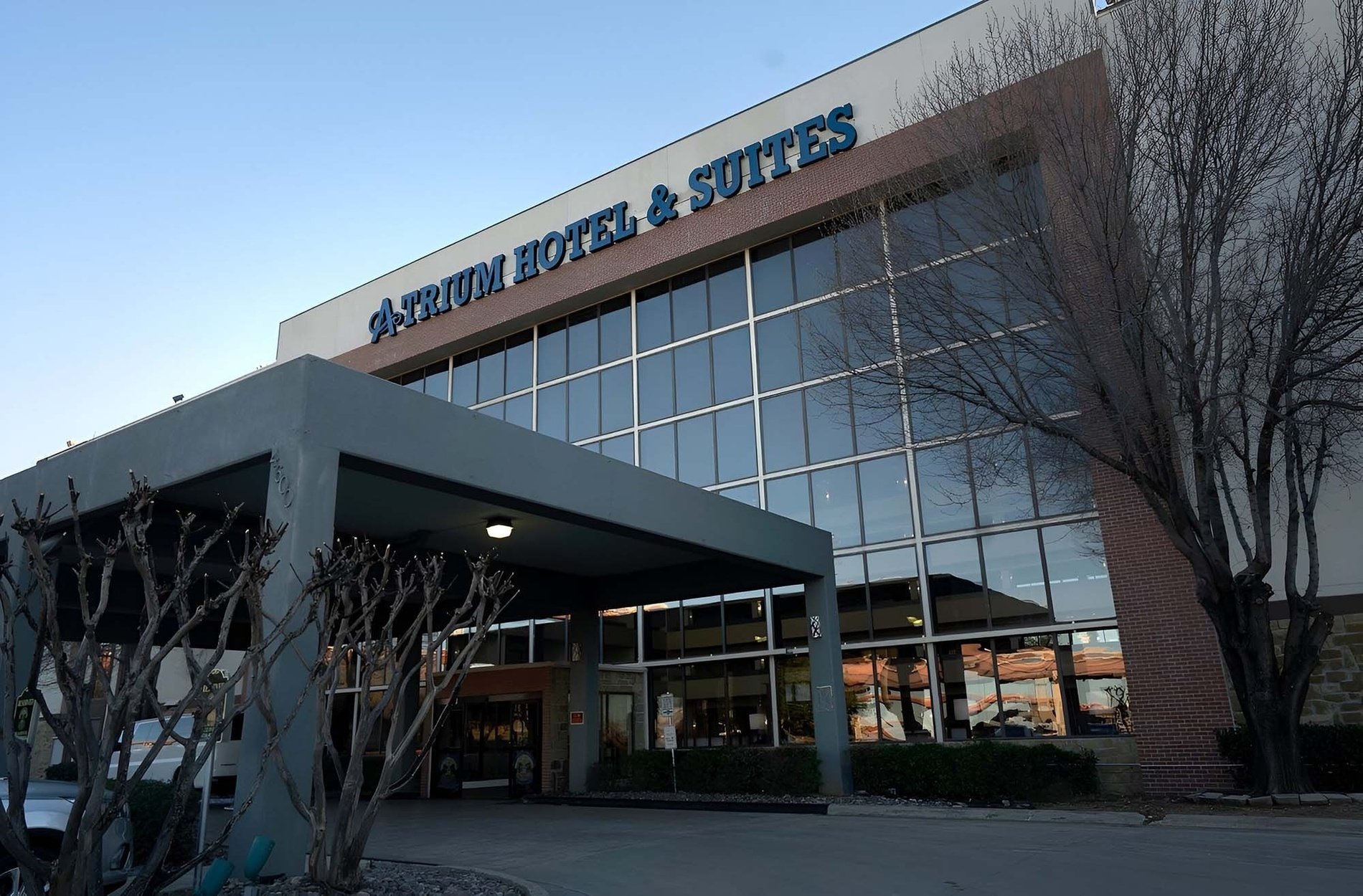 atrium hotel and suites is a large building with lots of windows