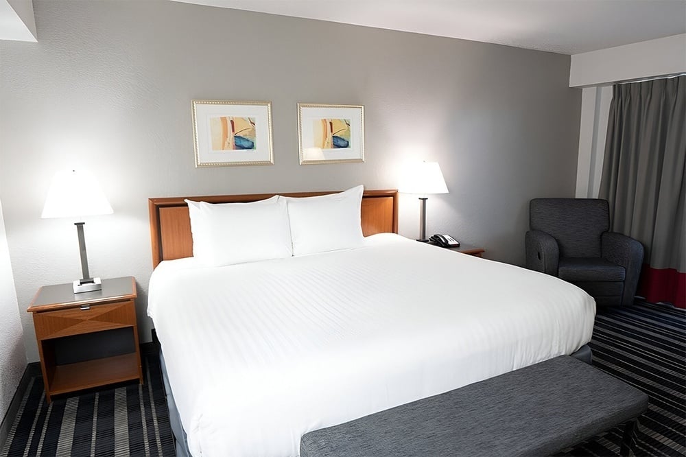 a hotel room with a bed and two pictures on the wall