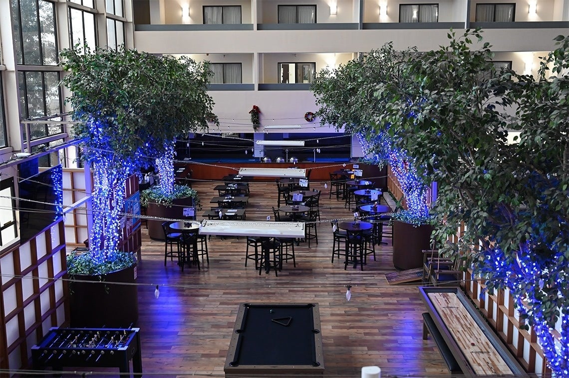 a large room with tables and chairs and a pool table