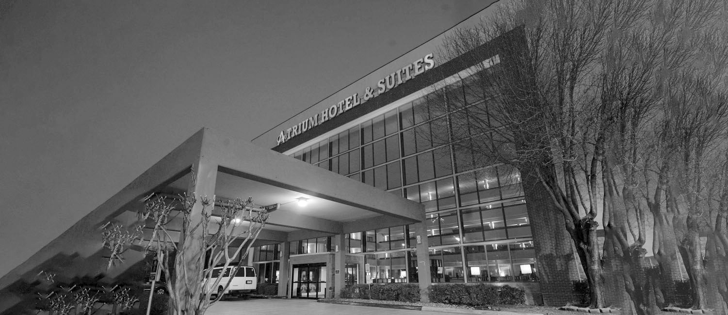 a black and white photo of a swimming pool with chairs and umbrellas=s1900
