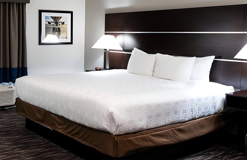 a hotel room with a large bed and a lamp